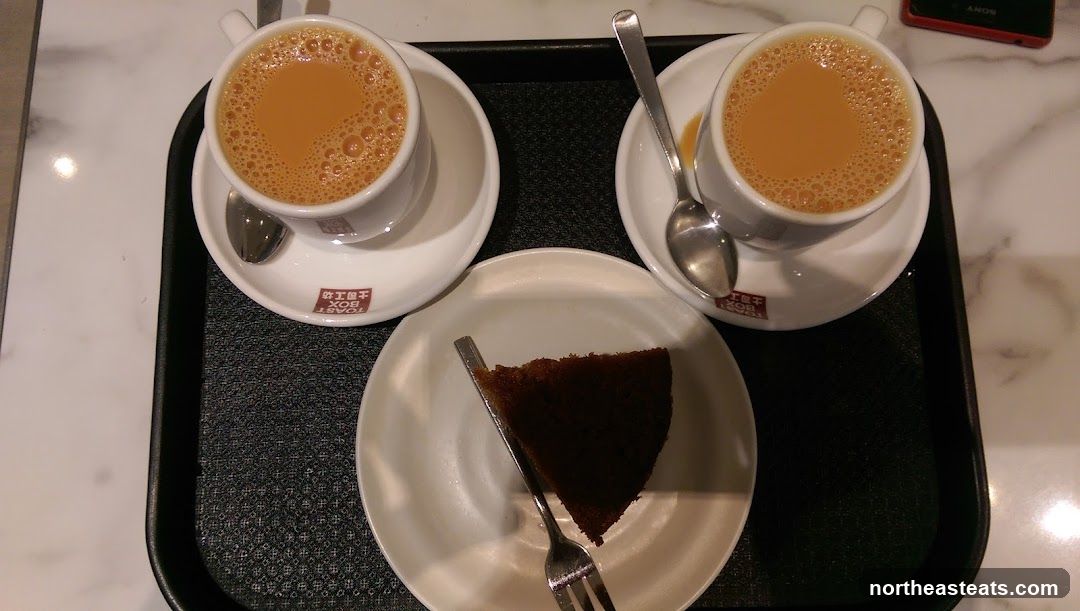 Two cups of tea and a slice of cake
