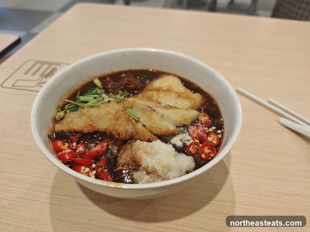 Bowl of Food with Sliced Chilies and Fried Pieces