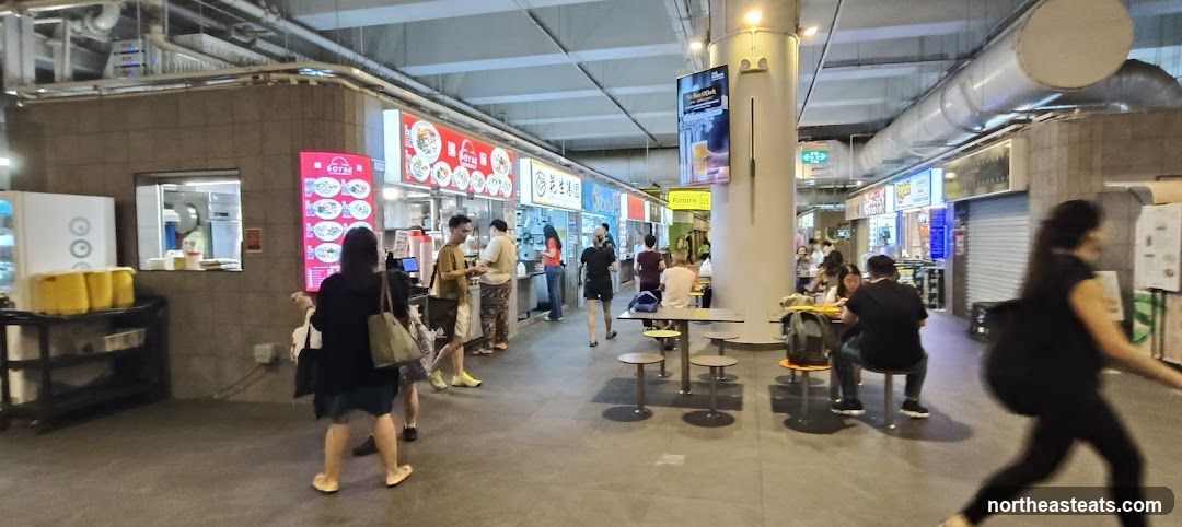 Food court with various stalls and seating areas