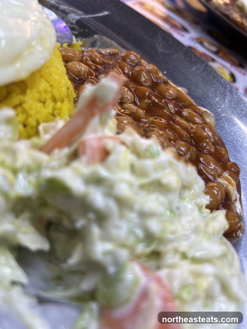 Close-up of a meal with rice, beans, and coleslaw