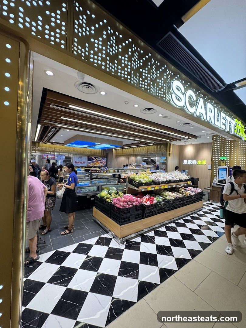 The exterior of a supermarket with a prominent "SCARLETT" sign. The store features a black and white checkered floor and displays of fresh produce, including fruits and vegetables. Several customers are visible inside the store.