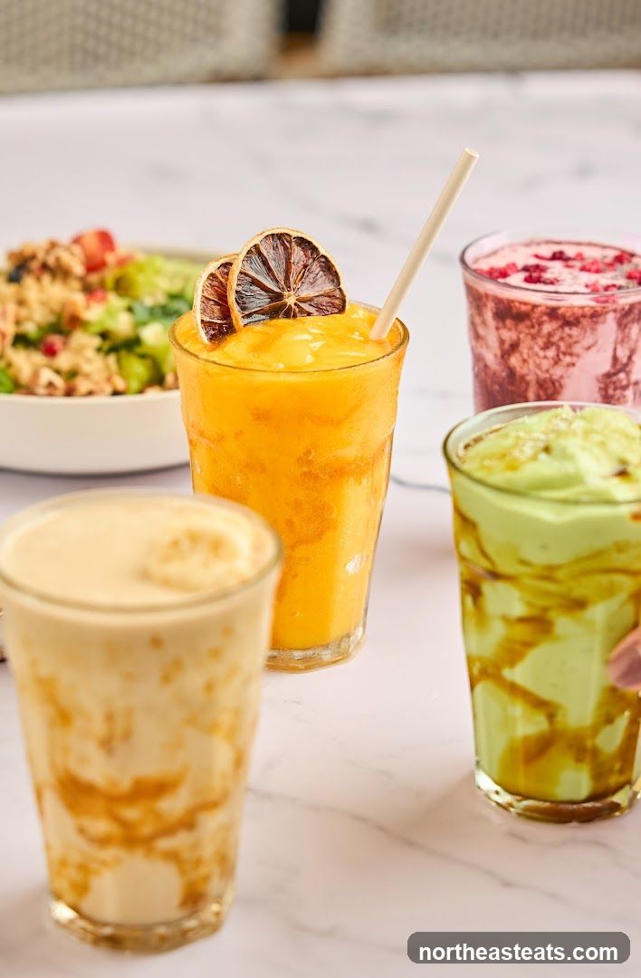 Four colorful smoothies and a salad