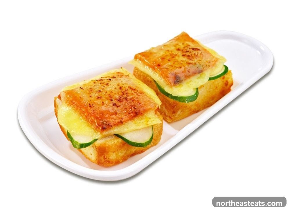 Two mini sandwiches with cheese and cucumber
