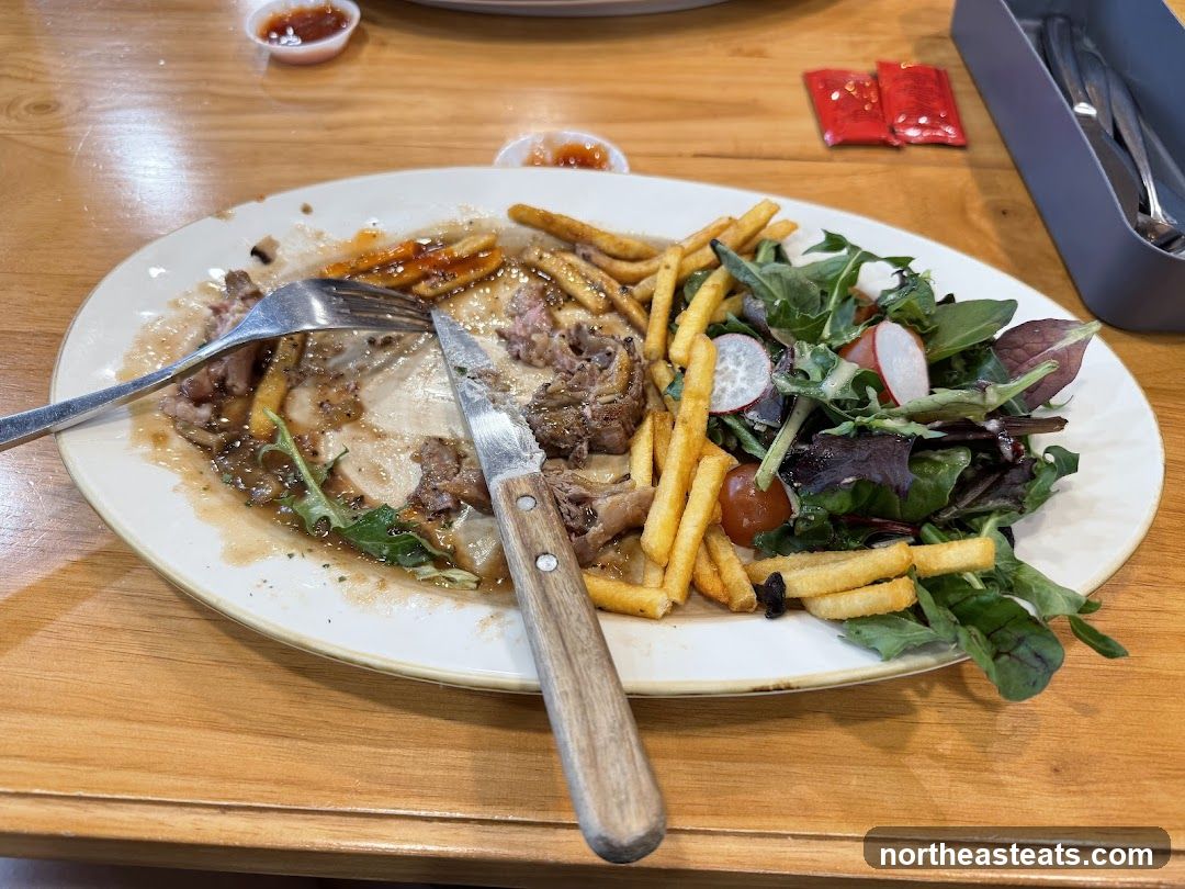 Half-eaten steak and fries with salad