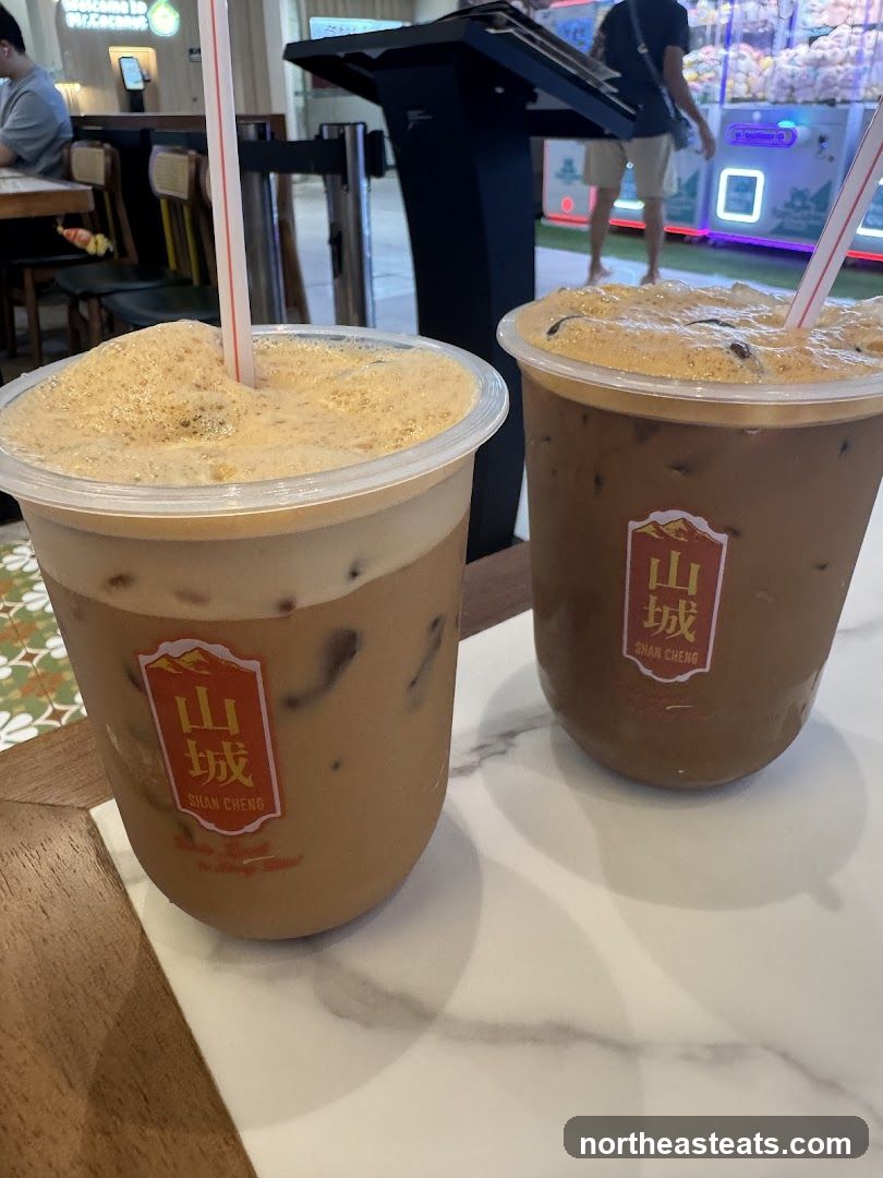 Two iced beverages with foam