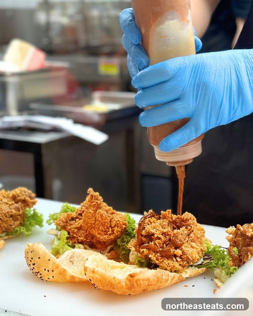 Adding sauce to fried chicken sandwiches