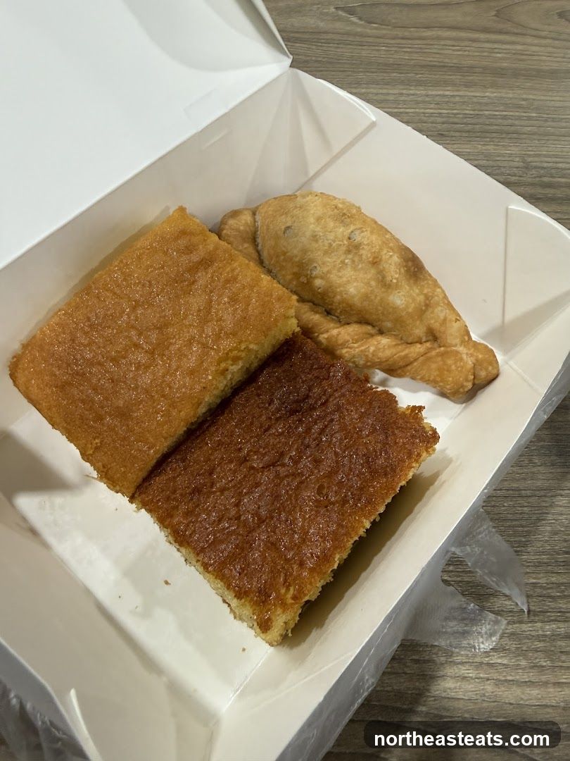 Two slices of cake and an empanada in a takeout box