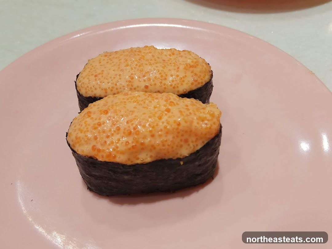 Two pieces of sushi with orange topping