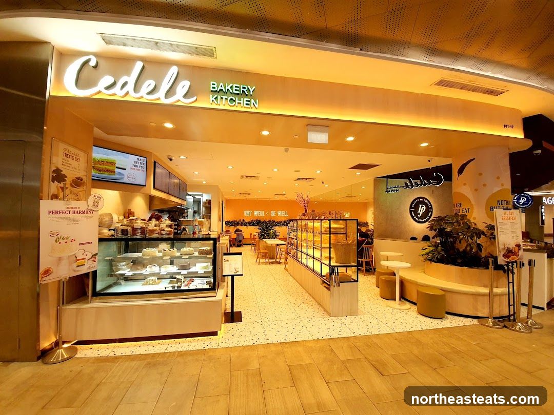 The exterior of a Cedele Bakery Kitchen with a prominent sign. Inside, display cases show cakes and pastries. Seating areas are visible, with tables and chairs. Promotional posters and menu boards are displayed.