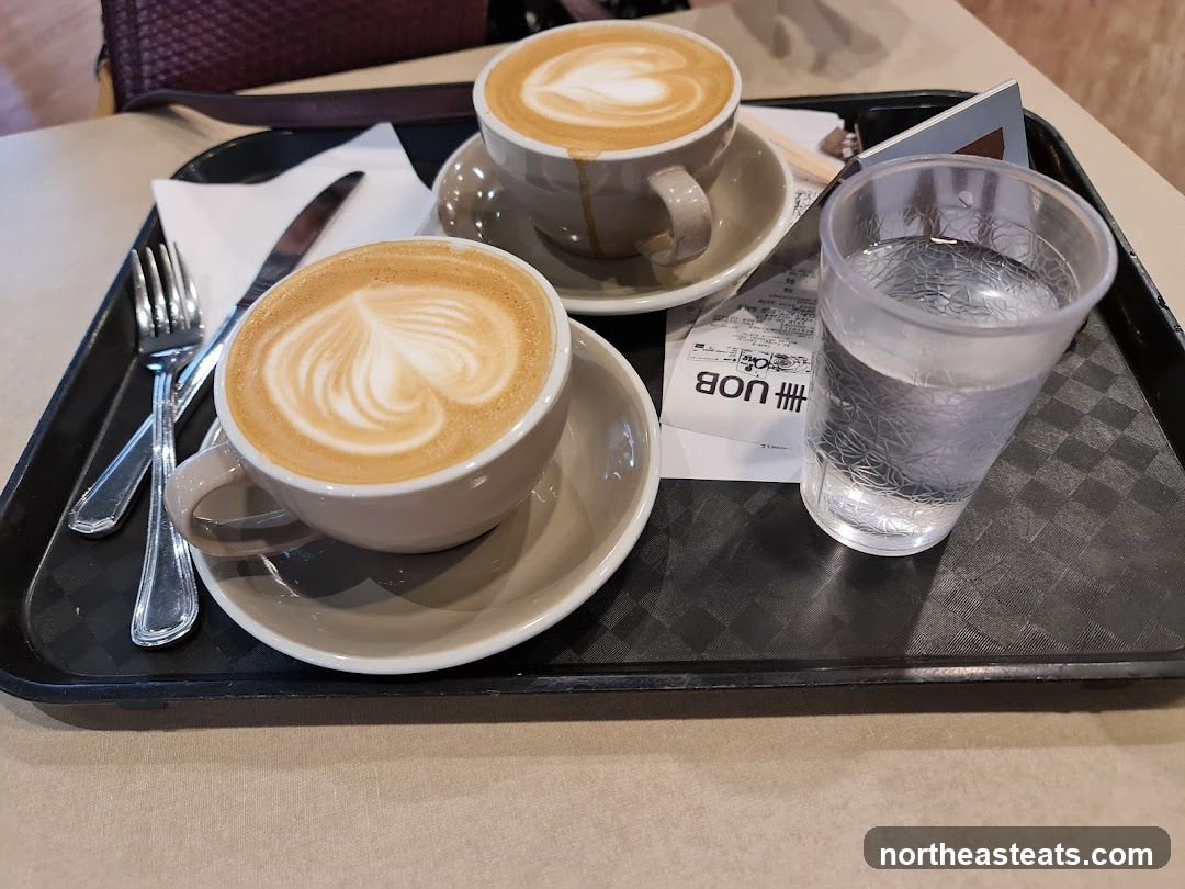 Two coffees and a glass of water on a tray