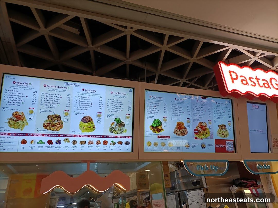 Digital menu board displaying various pasta dishes and toppings.