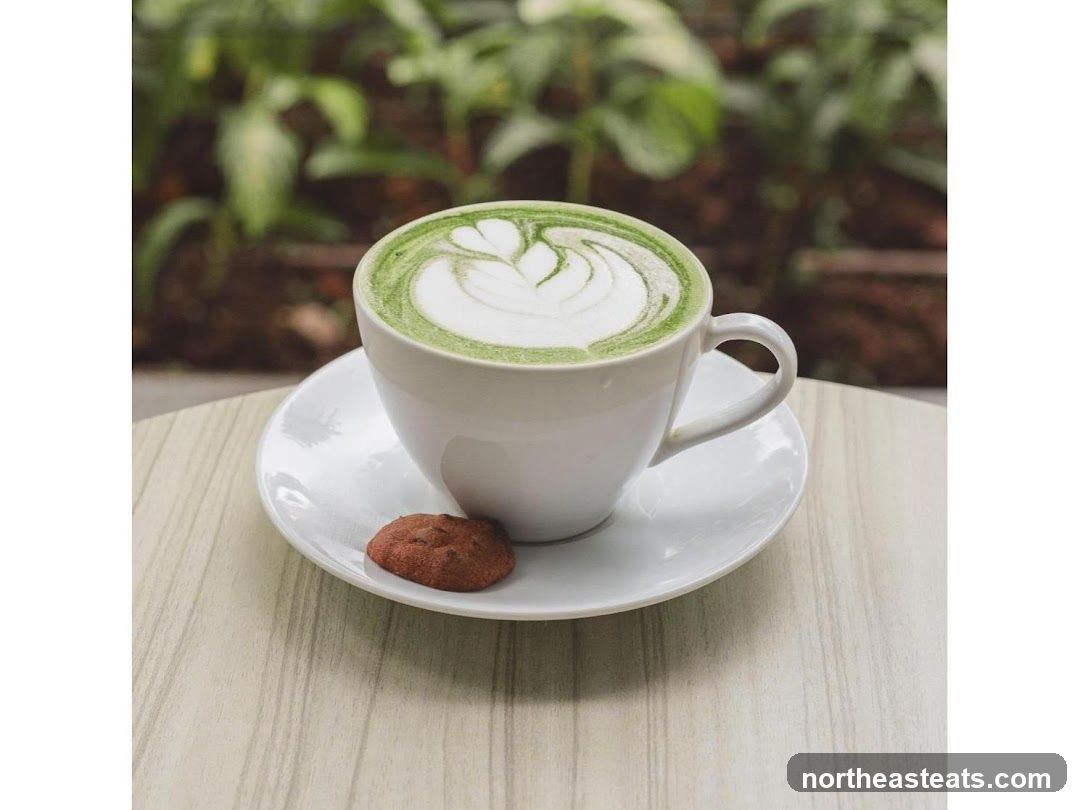 Matcha latte with latte art and a cookie