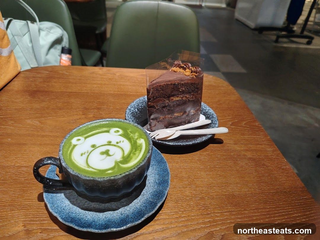 Matcha latte with bear art and chocolate cake