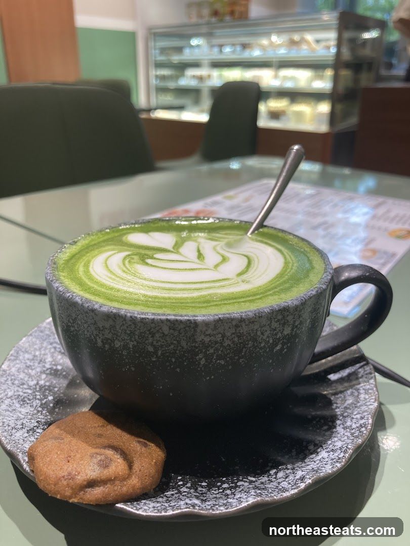 Matcha latte with latte art and a cookie