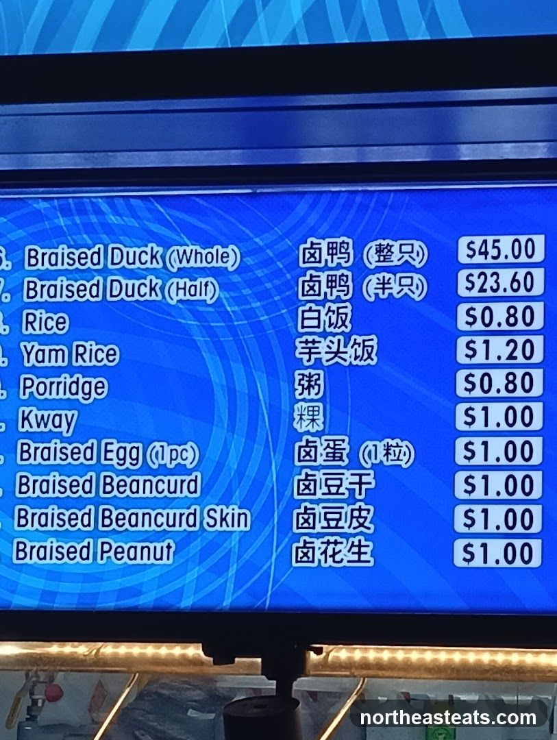 A digital menu board displaying various braised items and rice options.