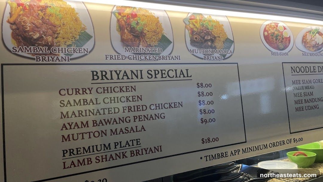 Menu board with pictures of various biryani dishes and a list of specials and noodle dishes.