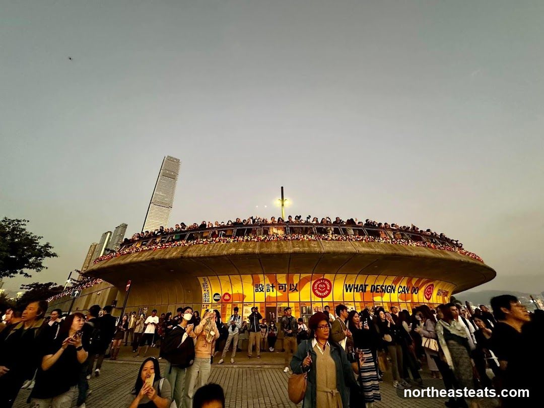 Crowd gathered at a circular building with signage