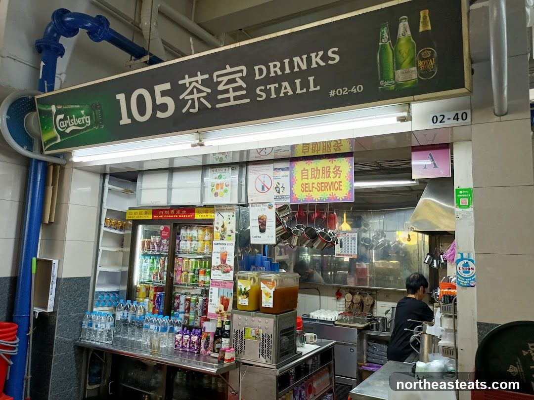 A drinks stall with a large sign displaying "105 DRINKS STALL" and images of beer bottles. The stall has a counter with various bottled drinks, cups, and dispensers. A person is visible working behind the counter.
