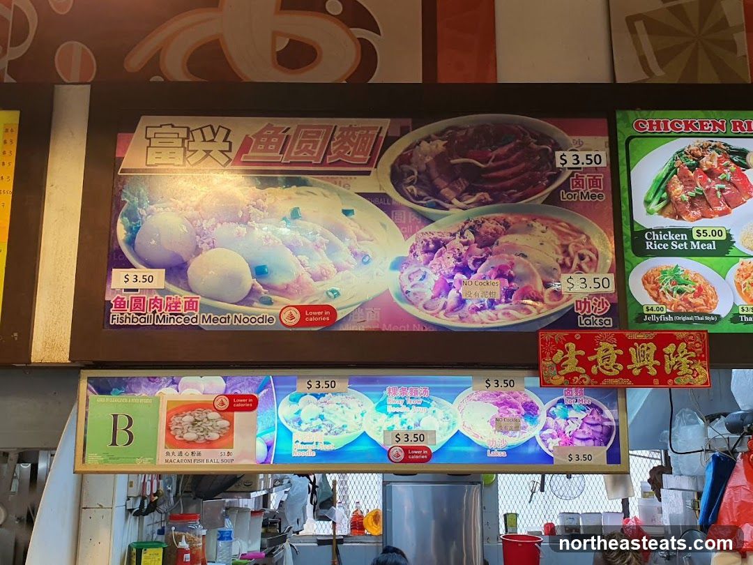 A food stall menu displaying various noodle dishes and set meals.