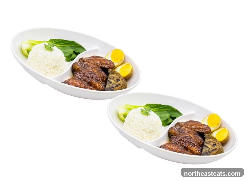 Two plates of braised chicken wings with rice and vegetables